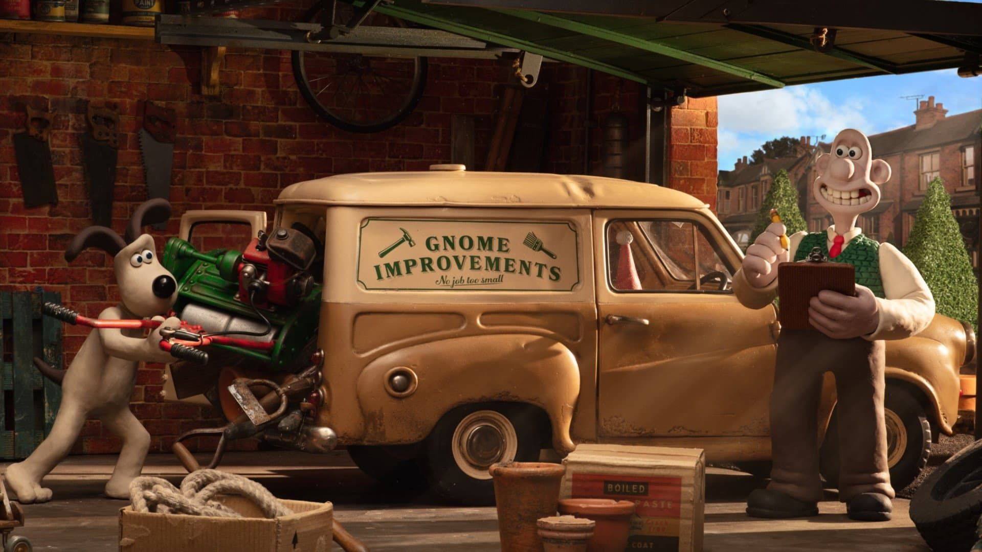 Wallace and Gromit beside a van labeled “Somes Improvements,” with tools and a brick workshop backdrop.