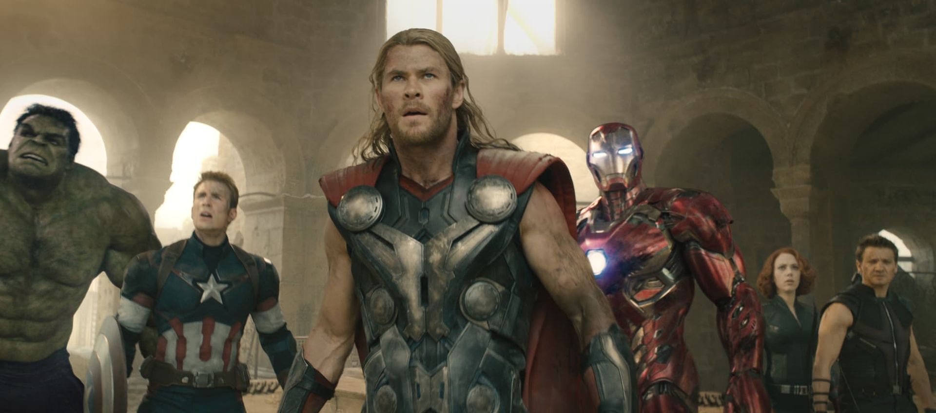 Superhero team stands together in a ruined hall, with Thor front and center and Iron Man, Hulk, and Captain America behind him
