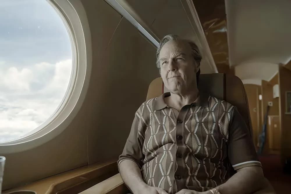 Person sitting by an airplane window, looking out with a thoughtful expression.