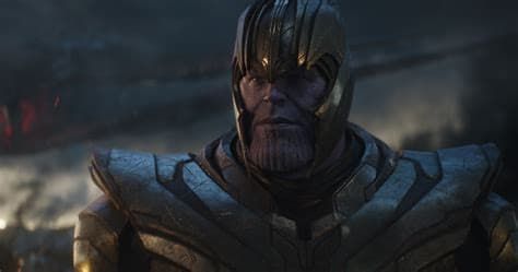 Armored Thanos with a stern expression, standing in a dim, smoky battlefield