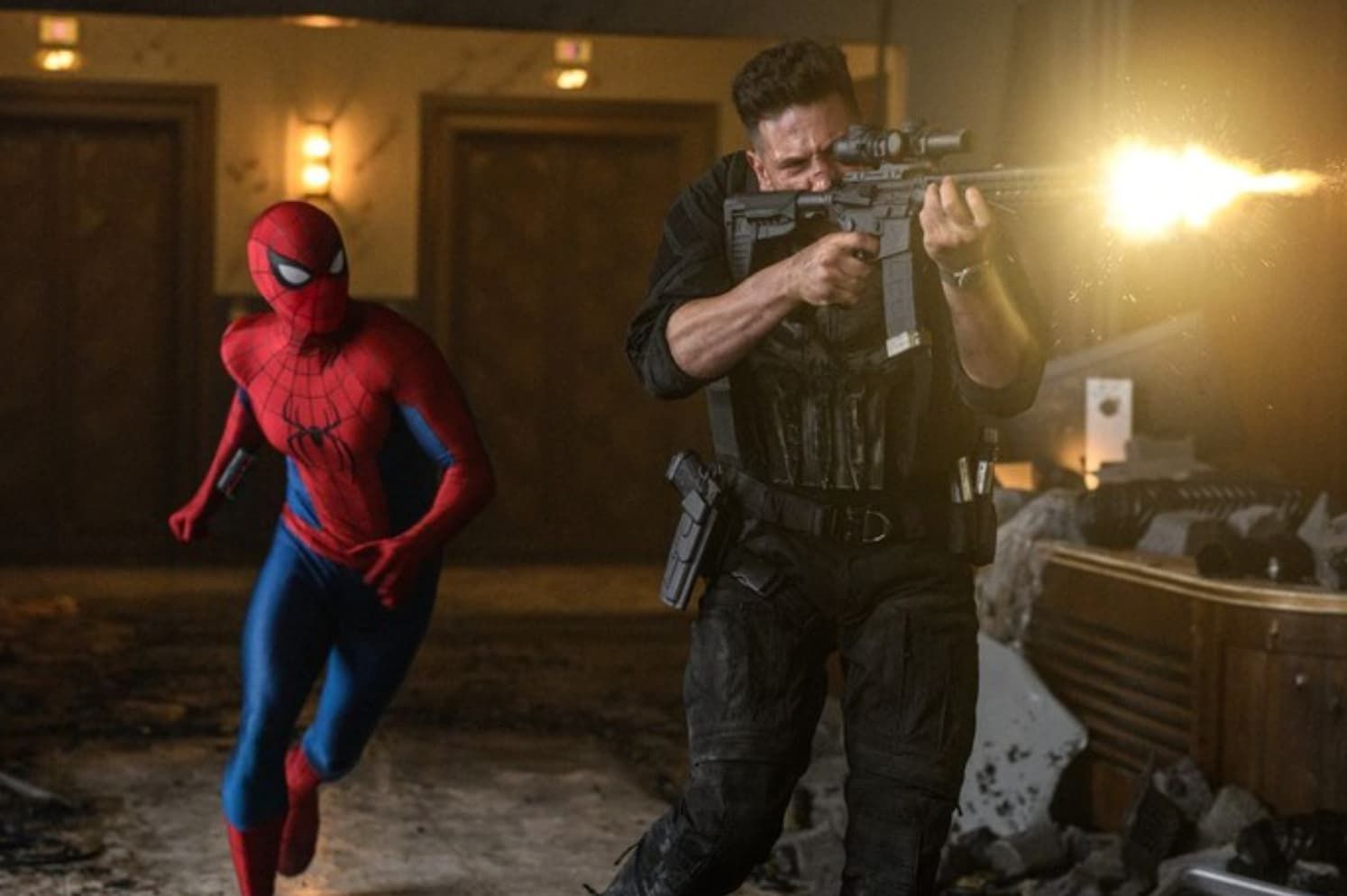 Spider-Man and the Punisher crouch in a dim room as gunfire flashes from the right.