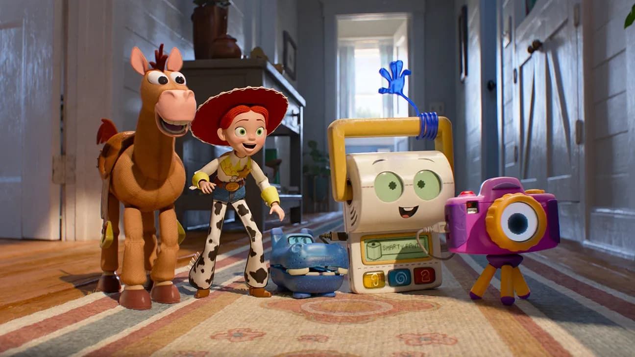 Toy Story characters Jessie, Bullseye, and friends standing in a hallway beside a robot and camera toy.