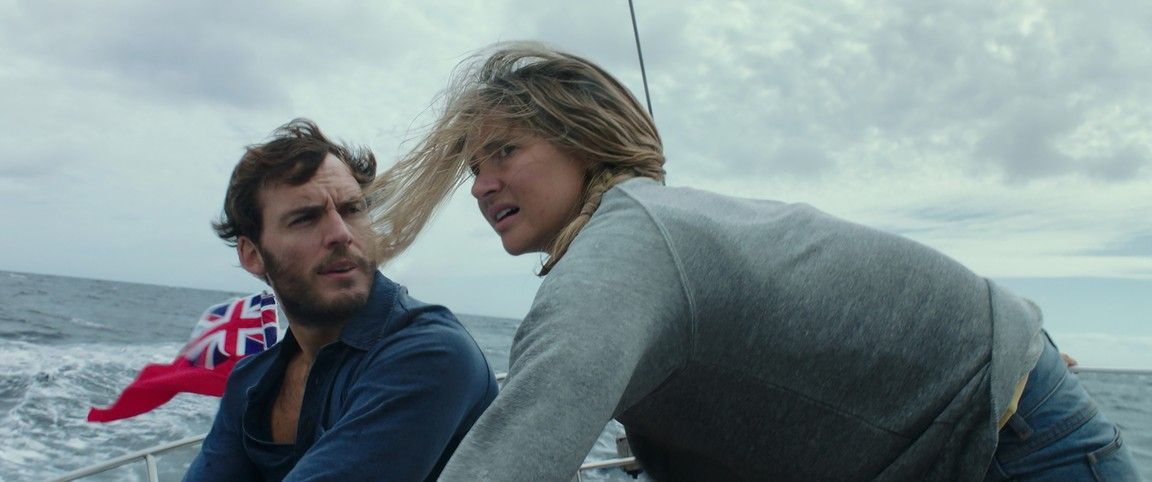 A man and woman on a boat in rough waters.