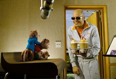 Alvin, Simon, and Theodore with their manager Dave, who holds milkshakes. Studio setting.