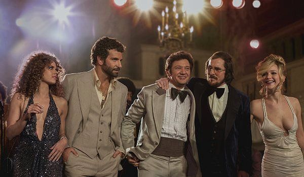 Five people at an event, 1970s attire. A group photo. Lights shine.