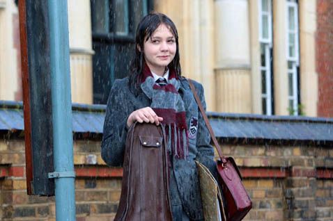 A young woman with wet hair in a school uniform