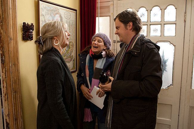 Three people smiling and chatting 