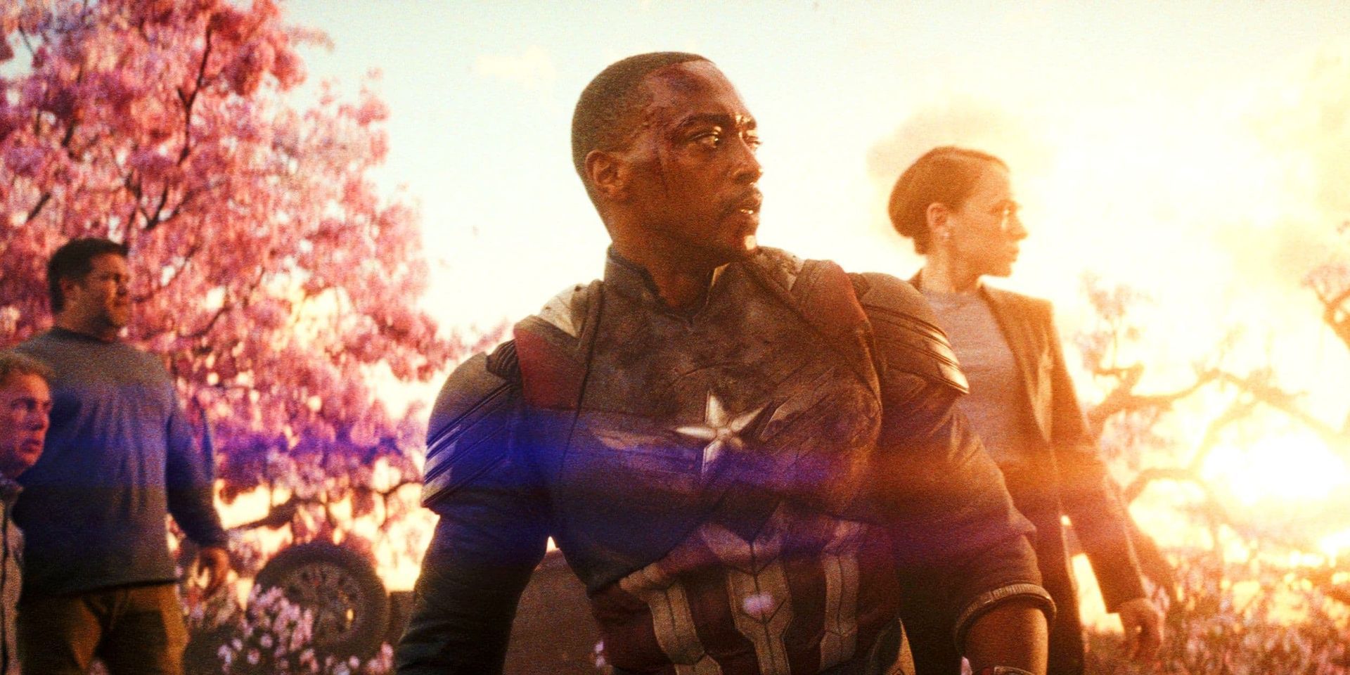 Superhero team stands in a sunset-lit field with pink trees and a glowing orange sky