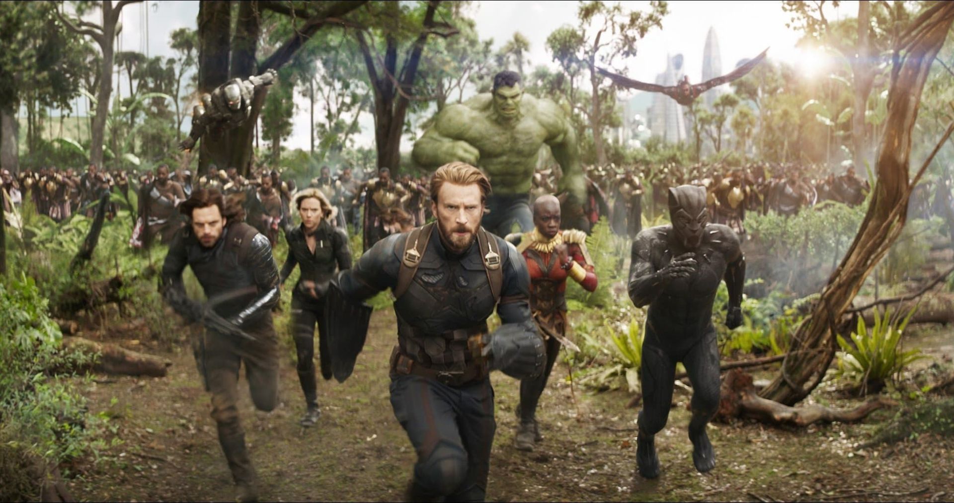 Superheroes running through a forest, led by Captain America with the team behind him.