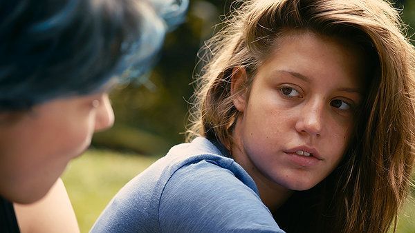 Woman with brown hair looks at someone off-screen. 
