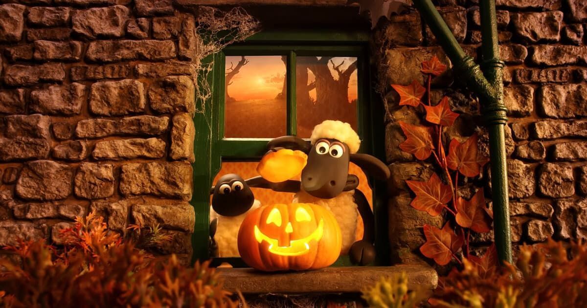 Halloween display with glowing jack-o'-lanterns by a window, lit by warm orange light