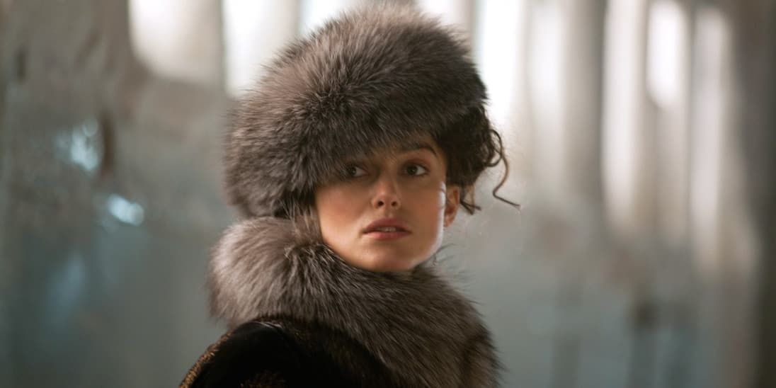 Portrait of a child in a fur hat and coat, looking at the camera in a softly lit setting