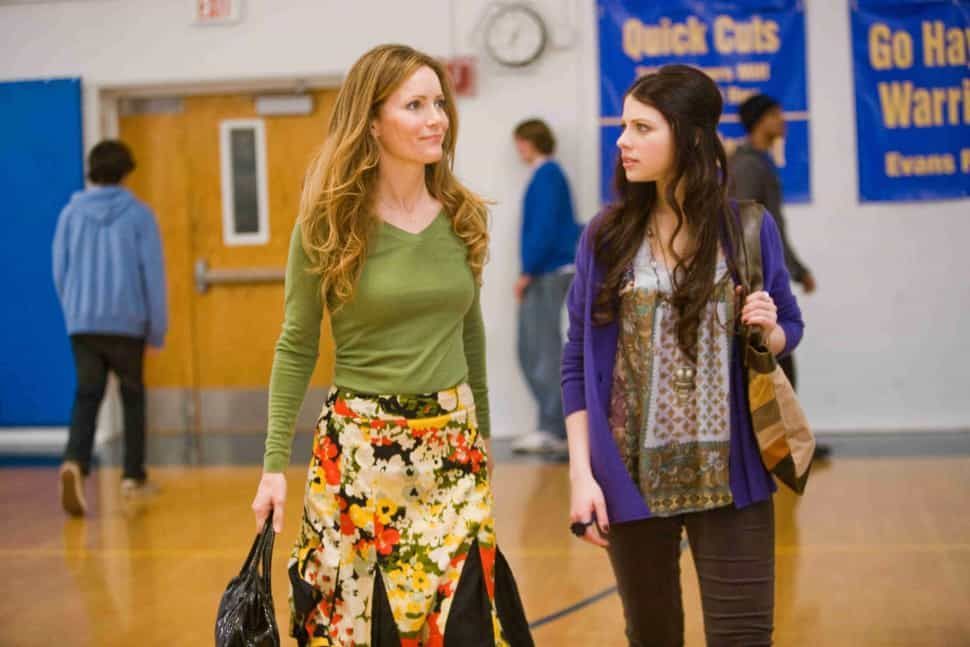 Woman in green and young woman in purple walking in a gymnasium.