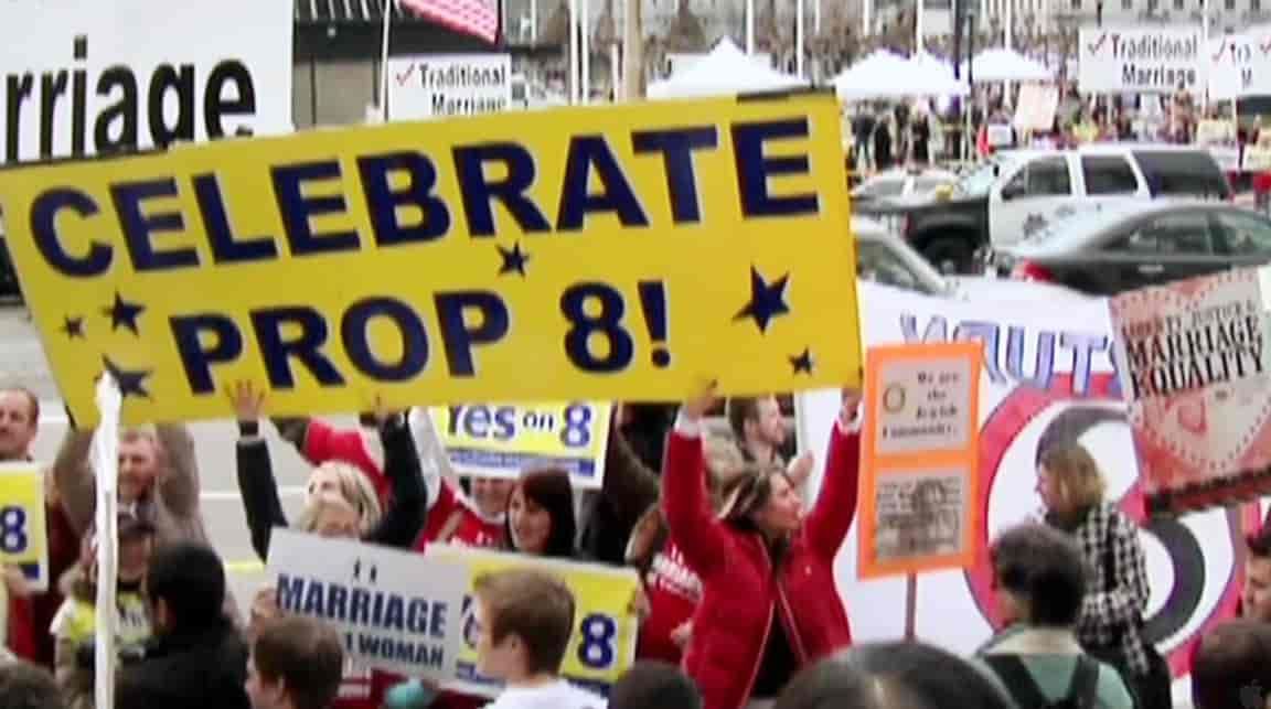 People protesting Prop 8, holding signs that say