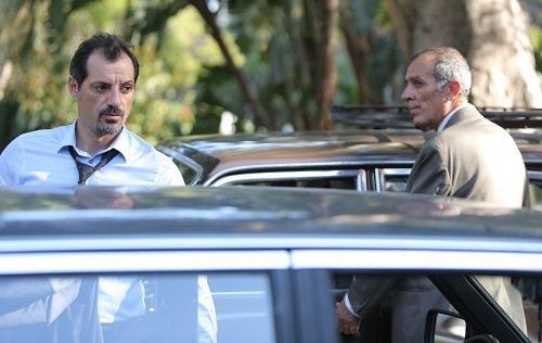 Two men beside cars outdoors