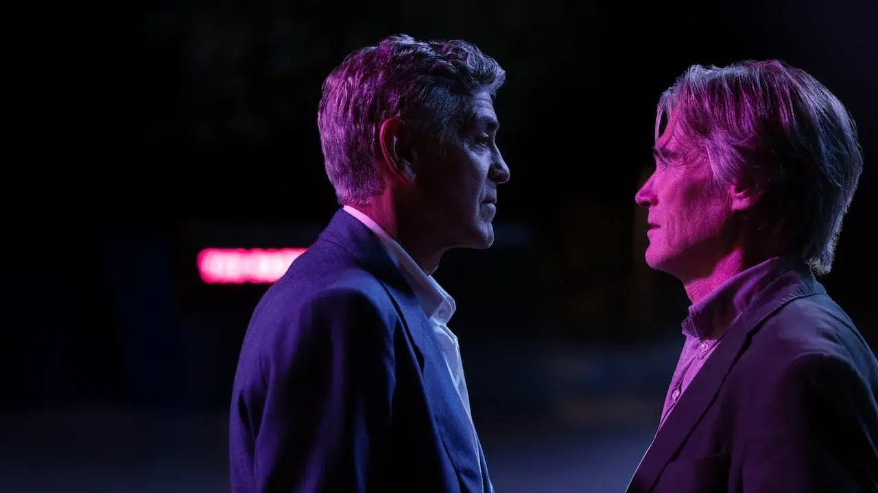 Two people face each other in profile under purple and pink stage lighting, standing close in a dark setting