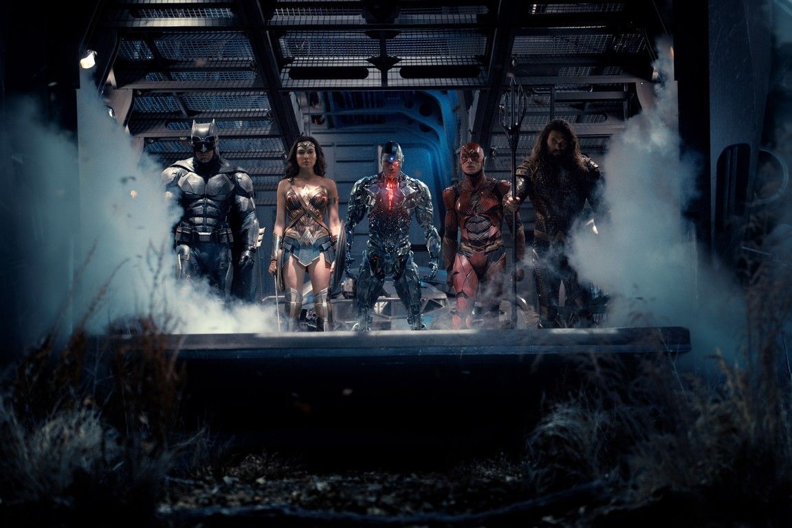 Justice League team assembled, standing in a dark, foggy setting. Batman, Wonder Woman, Cyborg, The Flash, and Aquaman.