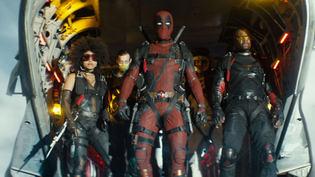 Deadpool and teammates stride forward from a aircraft, in red-and-black and black tactical suits, weapons ready