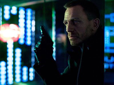 Daniel Craig as James Bond, holding a gun, in a high-tech setting with neon lights.