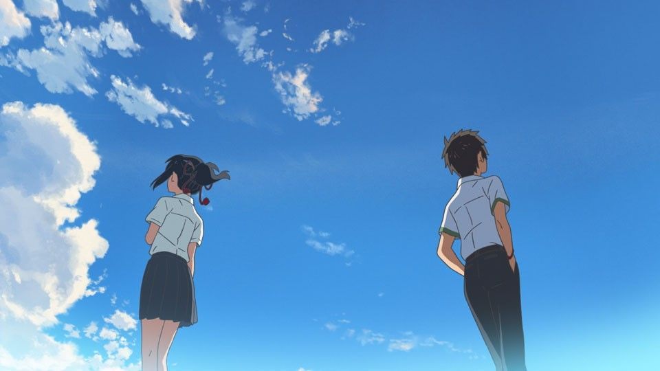 Two anime figures looking upwards at a blue sky with scattered clouds.