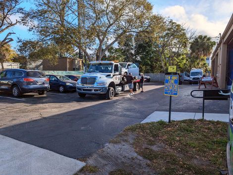 A tow truck loading a car in a parking lot | Dunedin Garage