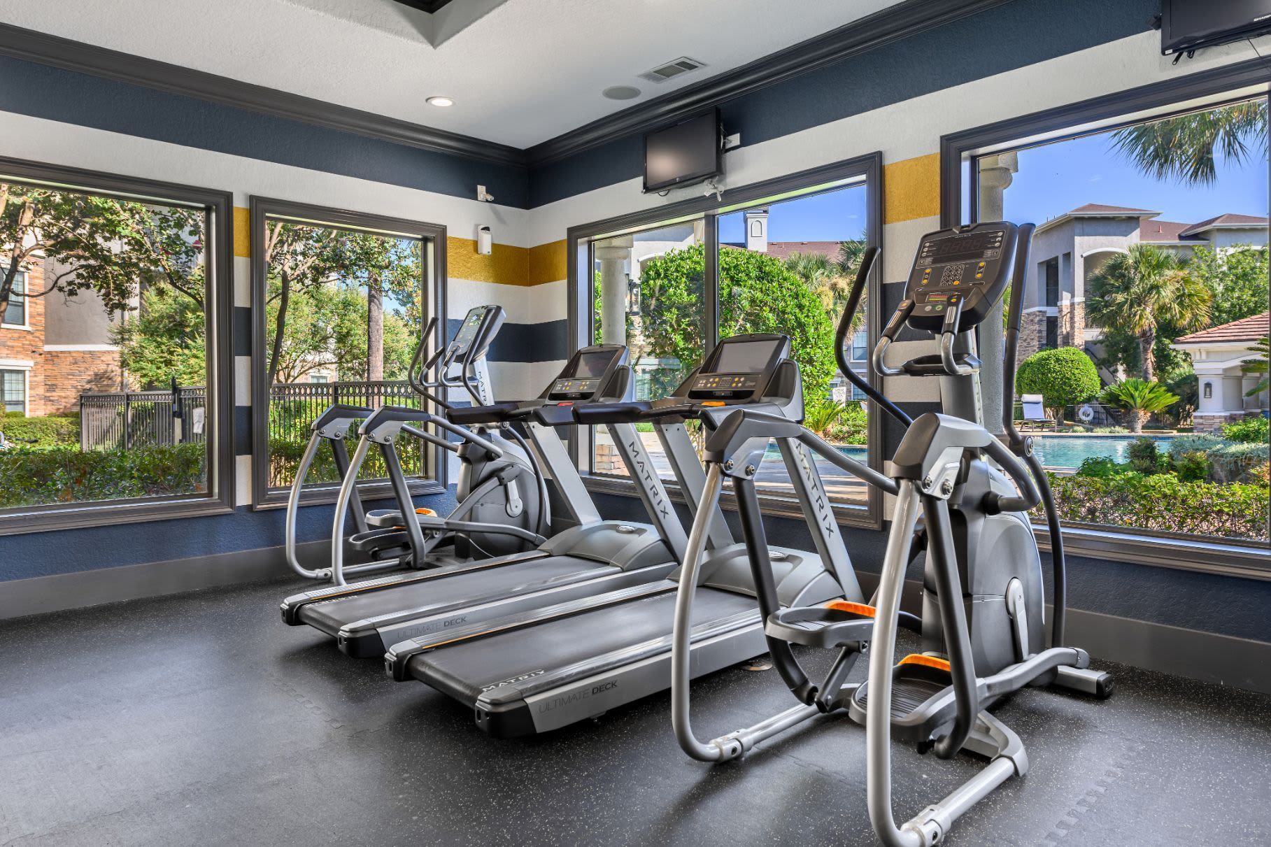 A gym with a lot of treadmills and ellipticals at Marquis Lakeline Station in Austin, TX.
