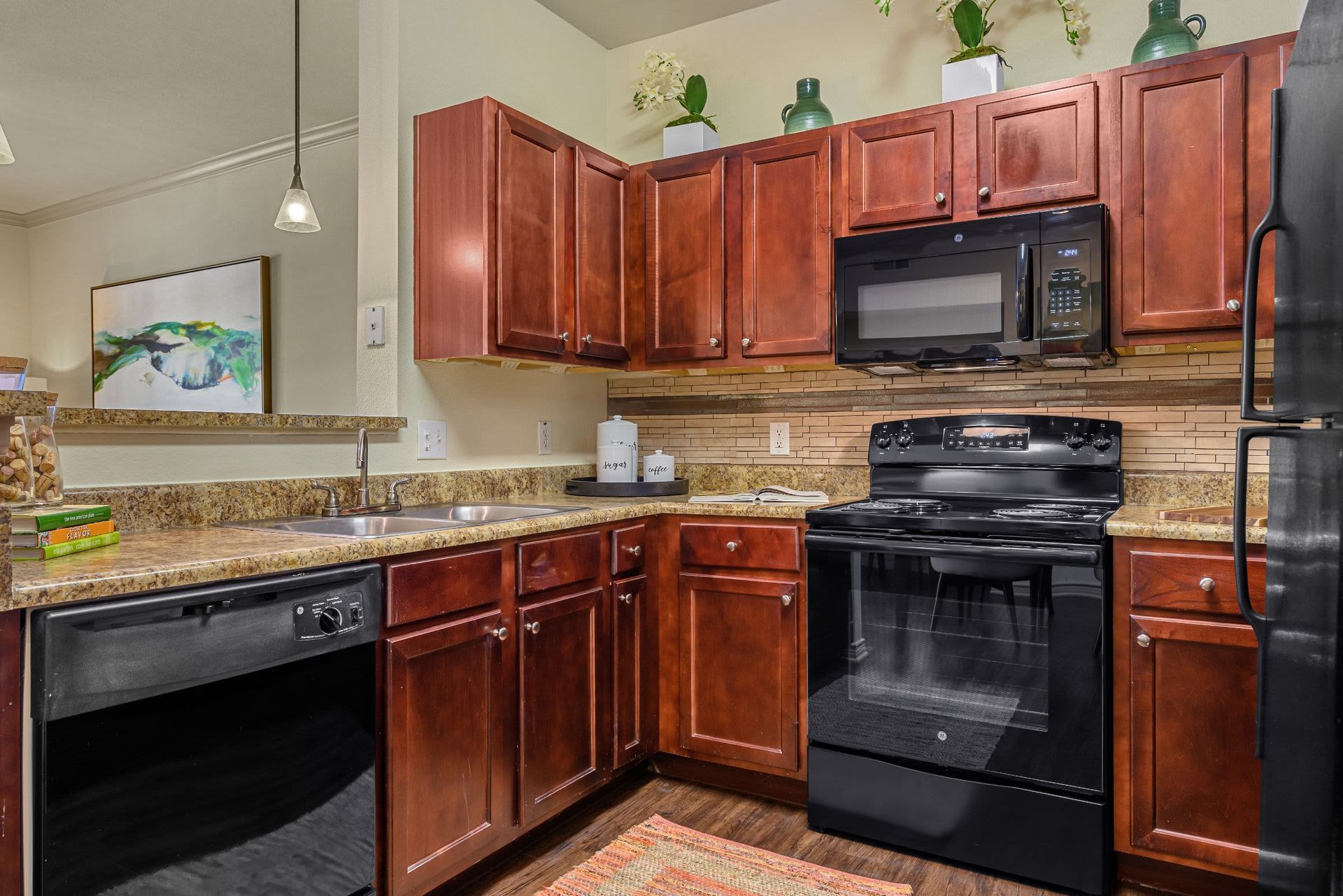 A kitchen with wooden cabinets and stainless steel appliances at Marquis Lakeline Station in Austin, TX.
