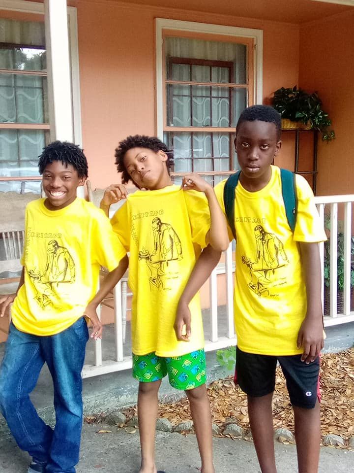 Three children in matching Phillip Simmons yellow shirts  .