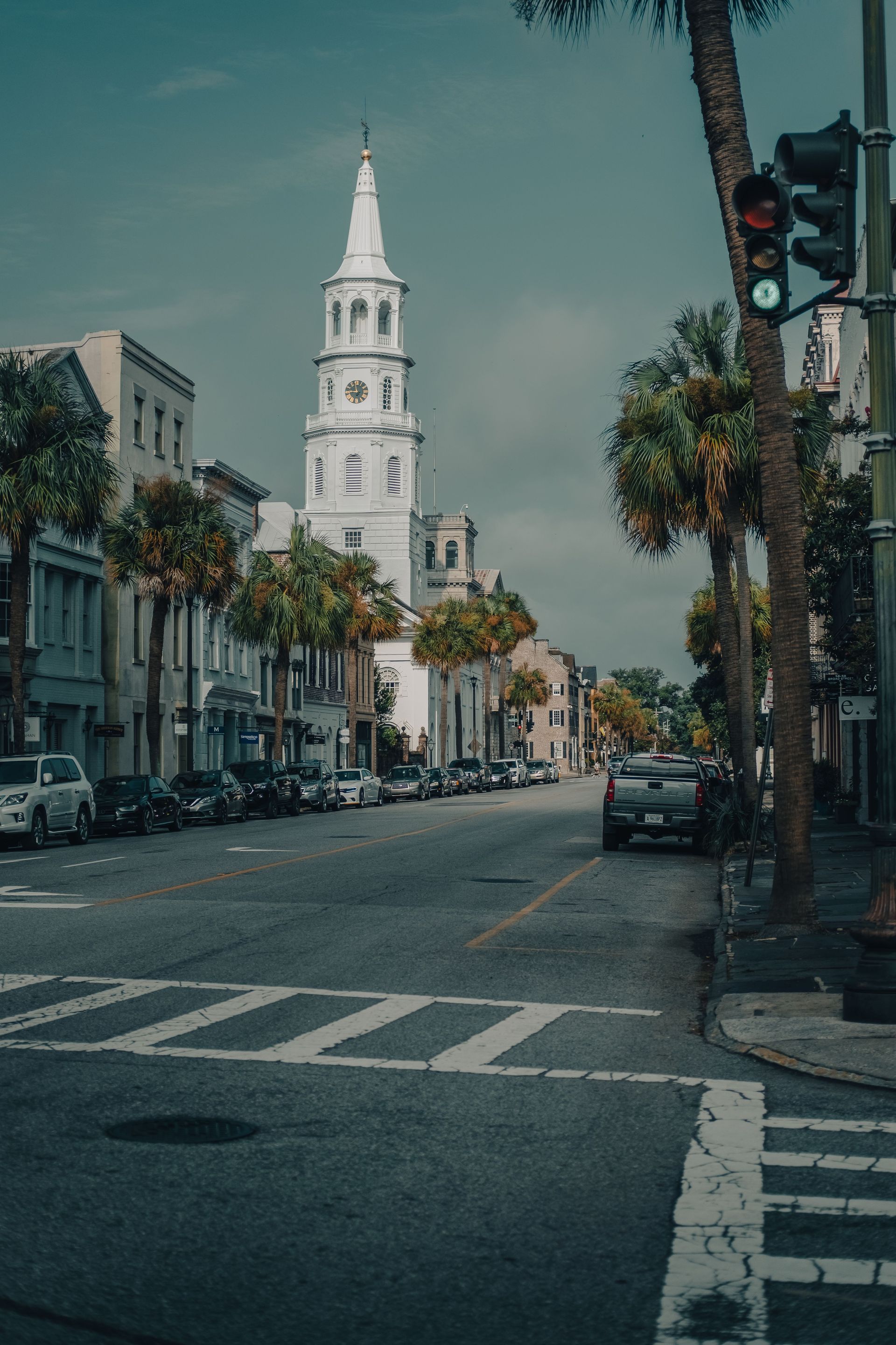A quiet Charleston street with palm trees and a church steeple