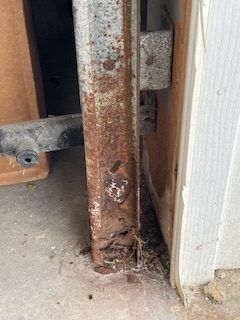 A close up of a rusty metal railing on a garage door.