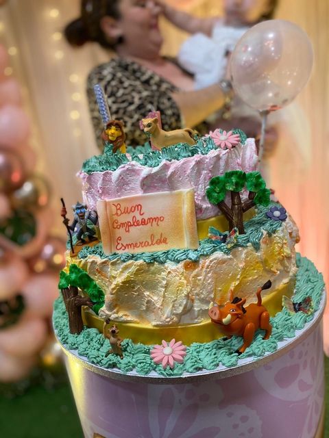 Una torta di compleanno a tema Re Leone è appoggiata su un tavolo.