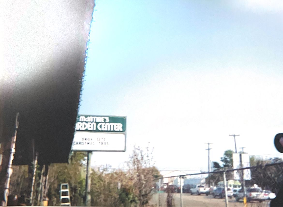 Street view with a Garden Center sign near a road under a bright sky