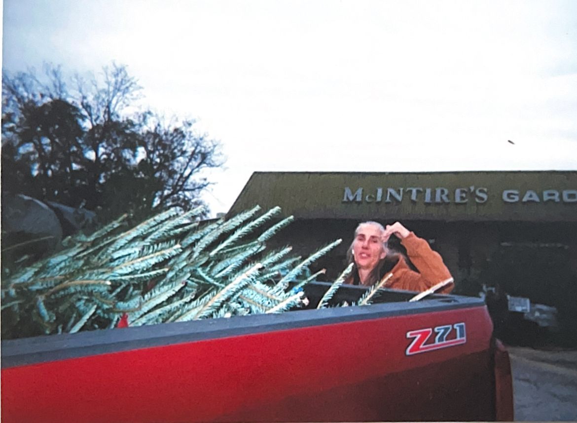 Person in a red boat holding a large catch near a garage sign at dusk