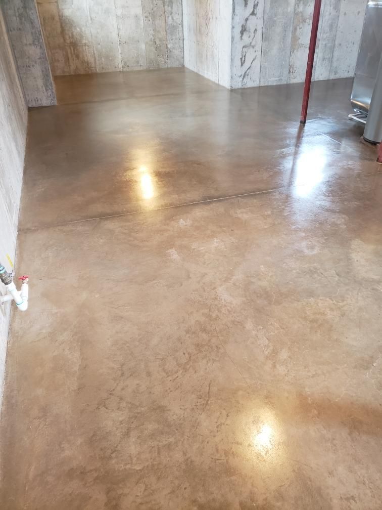 Polished concrete floor in an empty room with light reflections and stone-textured walls