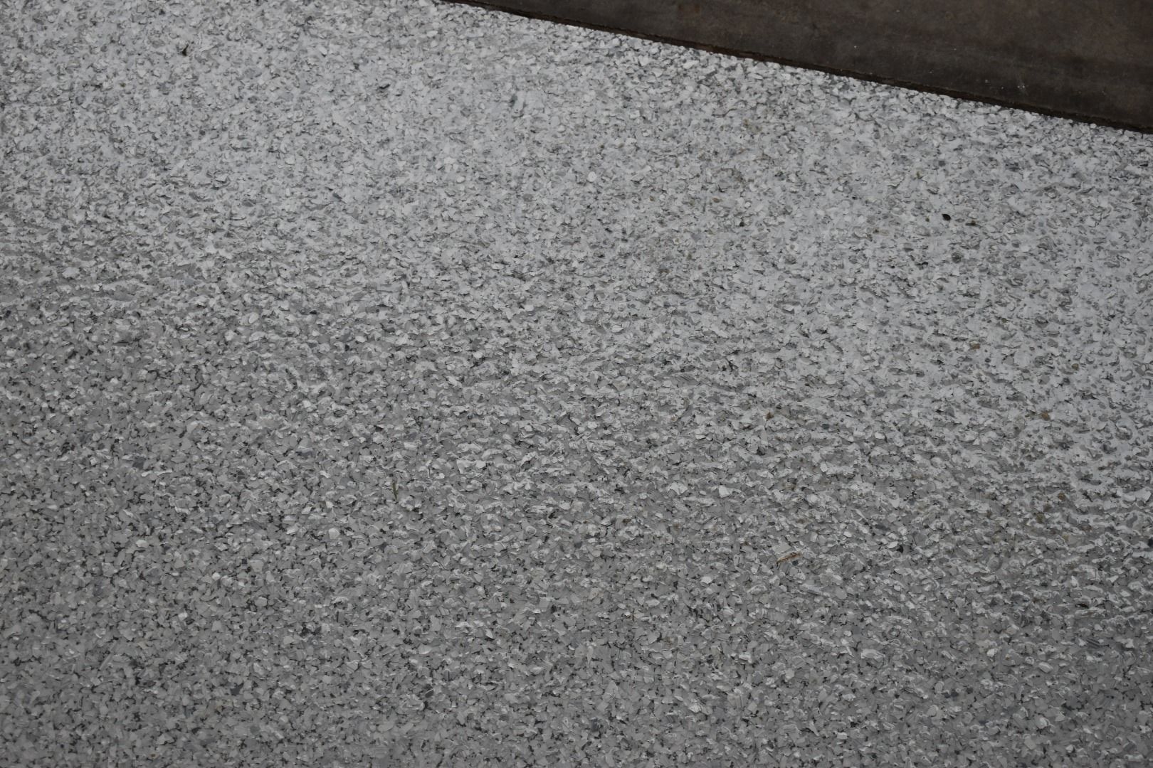 Close-up of gray textured surface with a dark diagonal strip at the top