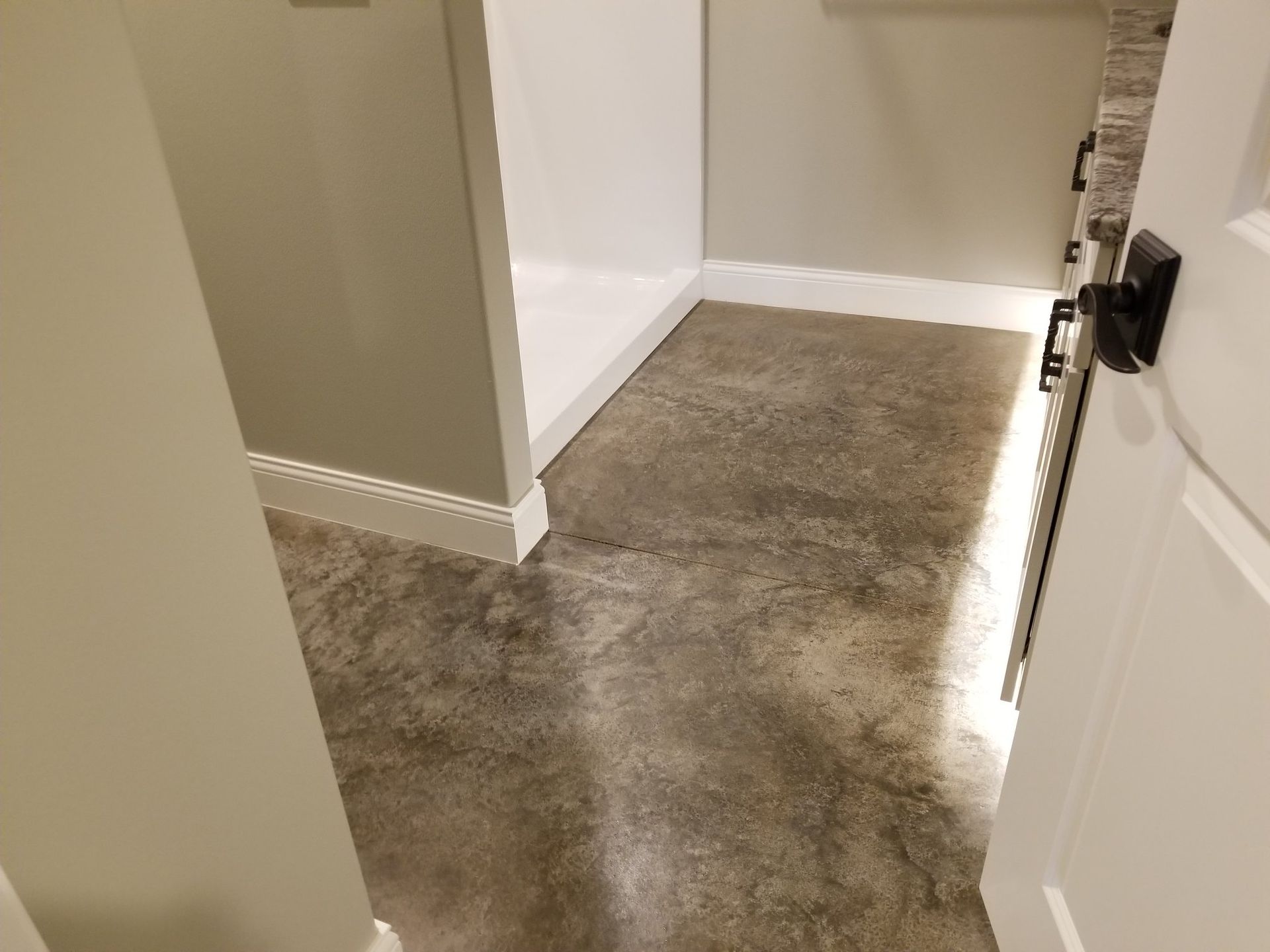 Hallway with gray carpet, beige walls, white baseboards, and a partially open door on the right
