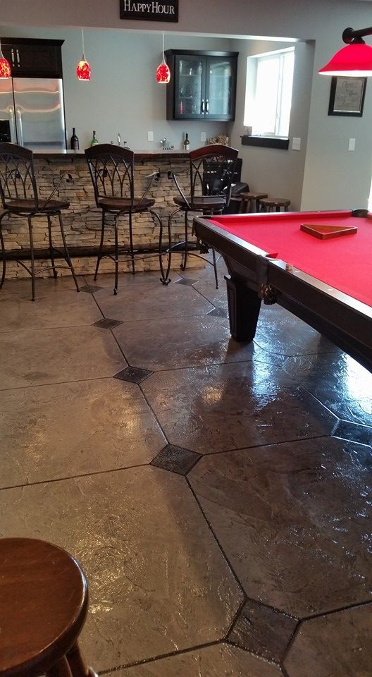 Game room with a red pool table, wooden chairs, and a shiny tiled floor.