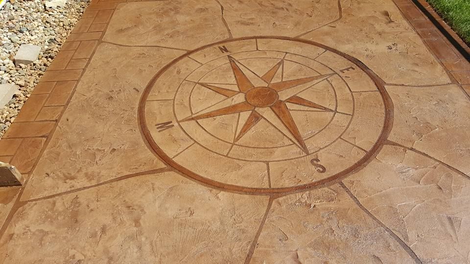 Stone walkway with a circular compass rose inlaid in the pavement, viewed from above