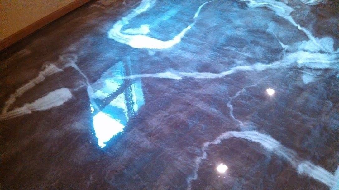 Reflective marble floor with blue-white light patterns and window reflections