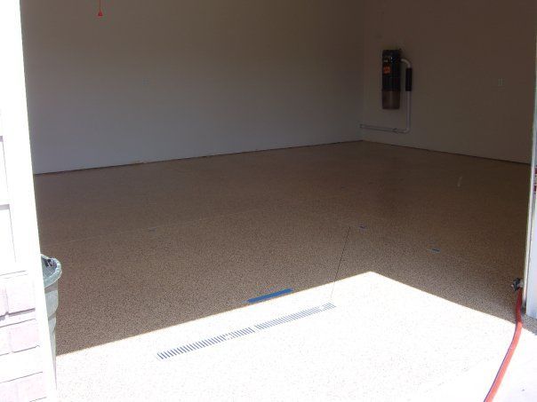Empty carpeted room with beige walls and a bright doorway in the foreground
