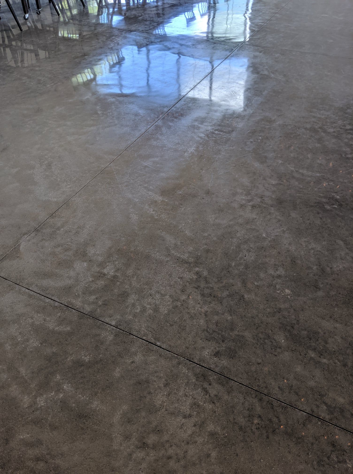 Shiny polished concrete floor reflecting windows in a bright indoor space