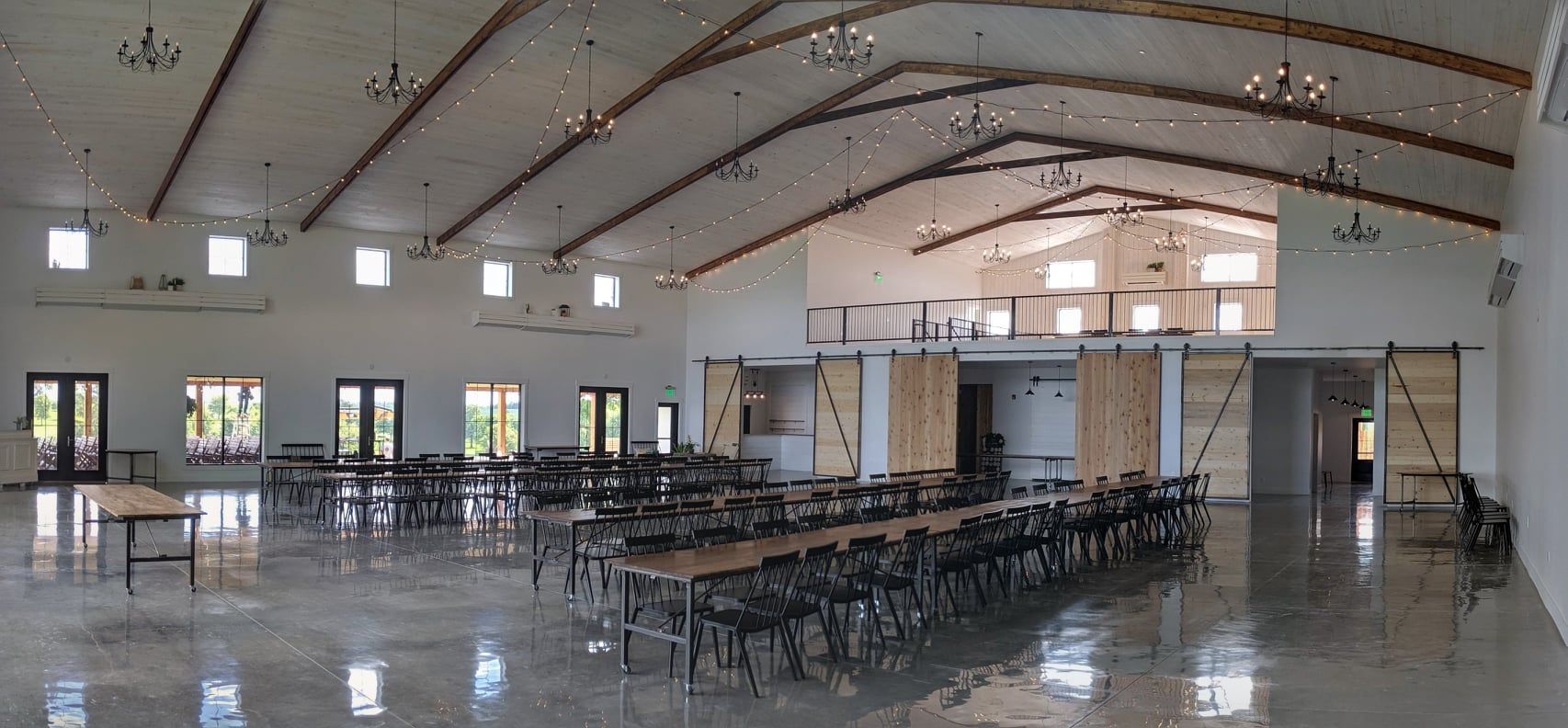Empty banquet hall with rows of chairs and a polished floor under a high arched ceiling.