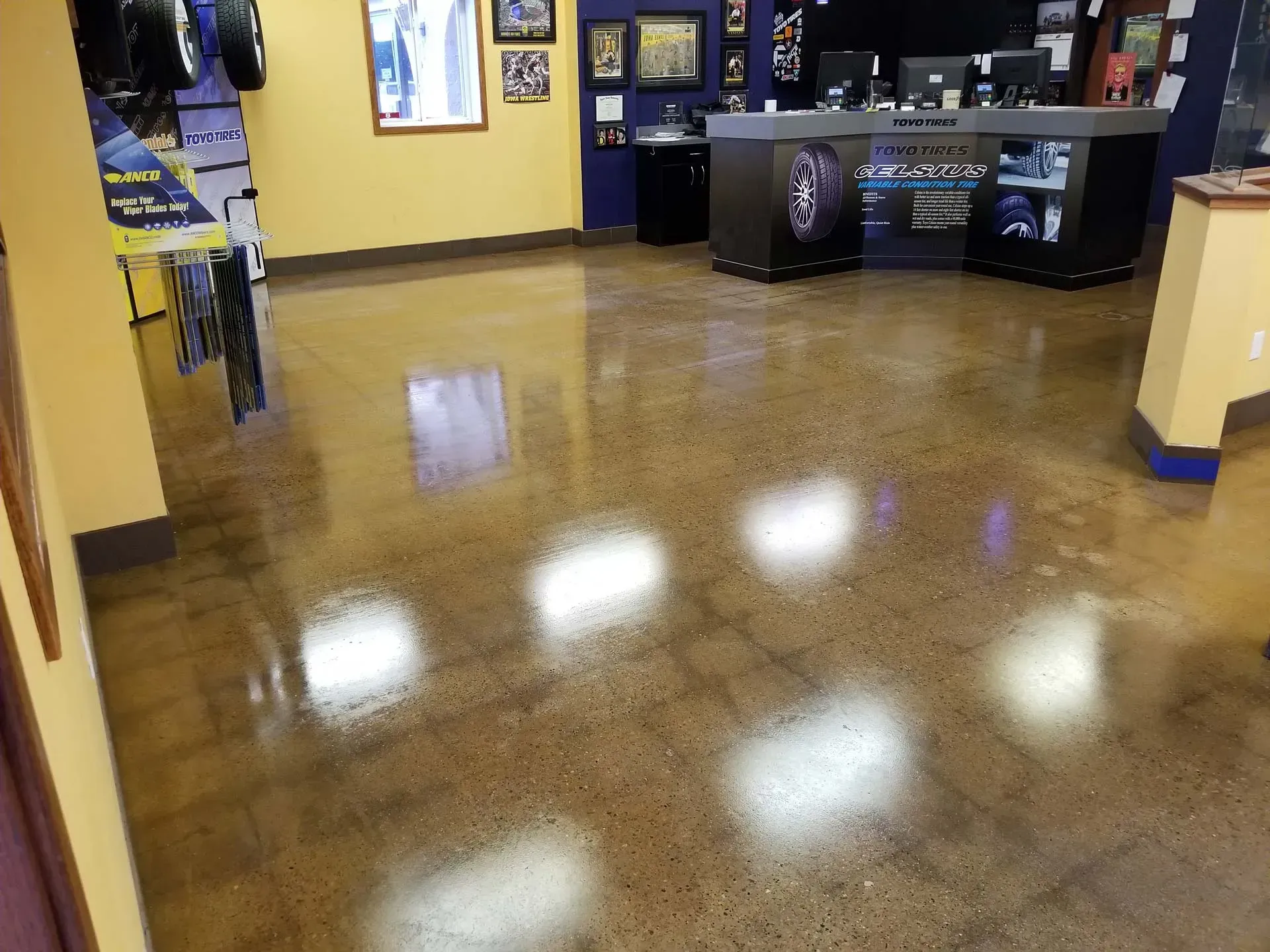 Empty lobby with glossy brown floor, yellow walls, and front counters in the background.