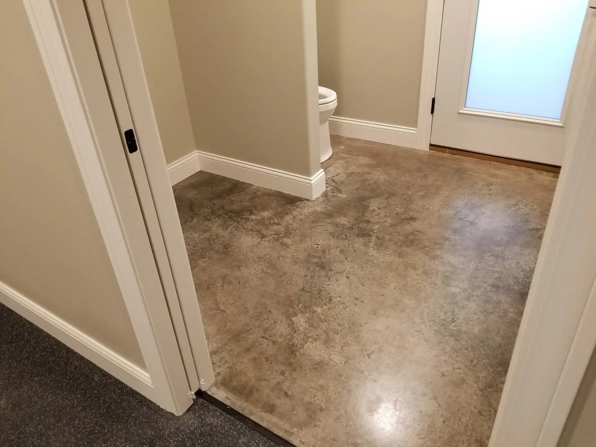 Carpeted hallway with beige walls, white trim, and a frosted glass door.