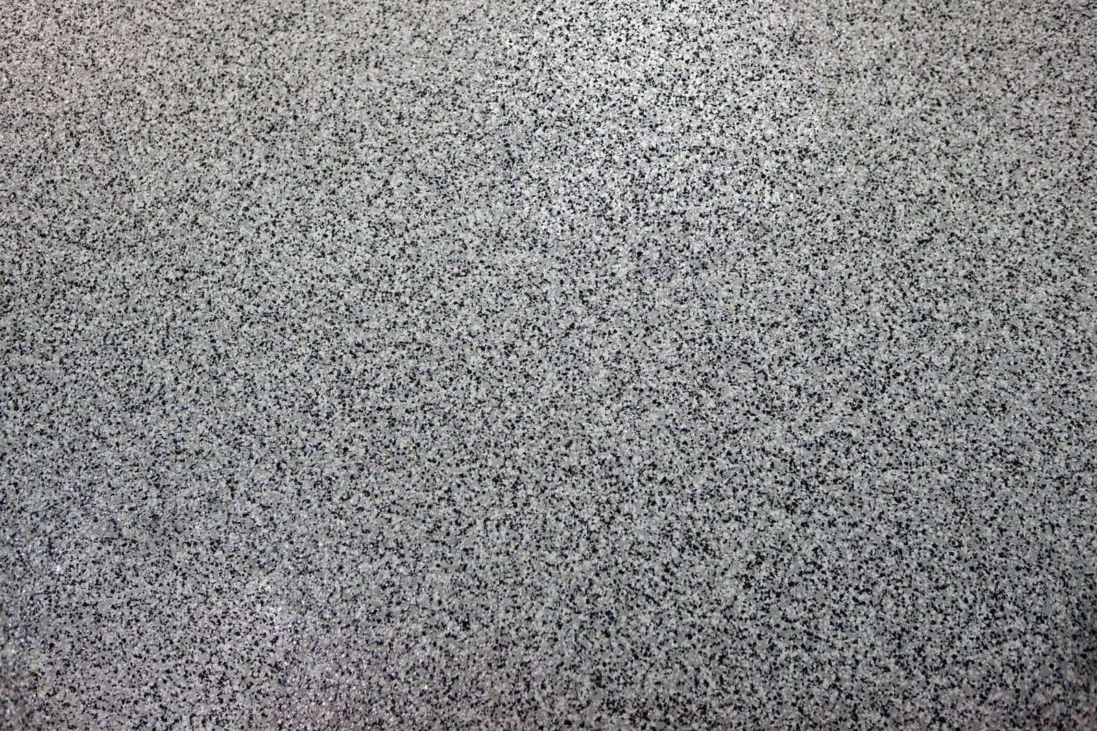 Gray TV static noise pattern with black speckles on a textured background