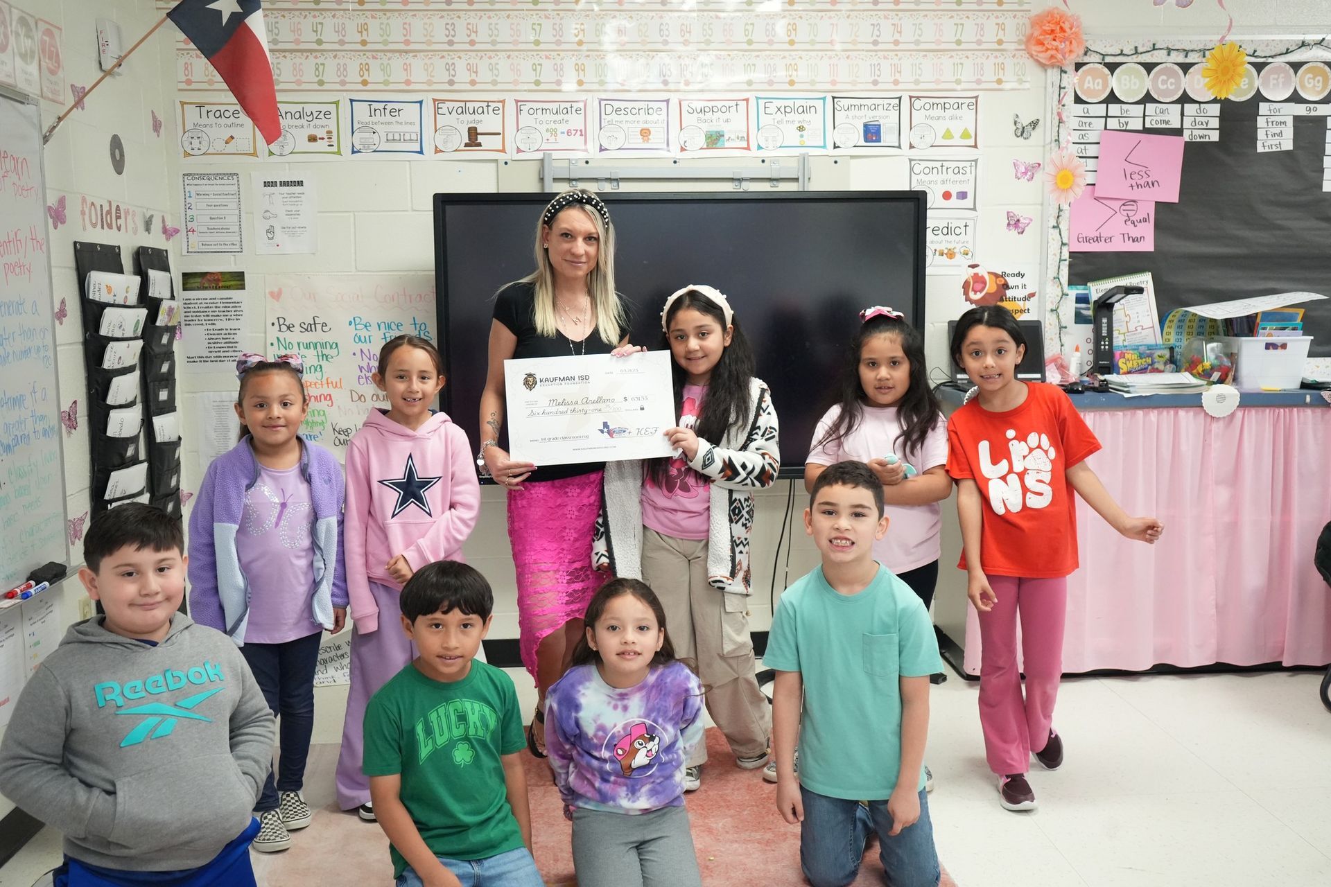 A group of children are posing for a picture in a classroom.