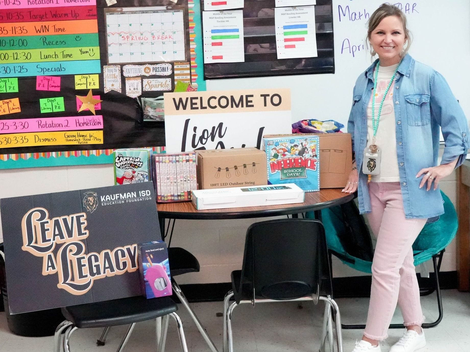 A woman is standing in a classroom in front of a welcome sign.