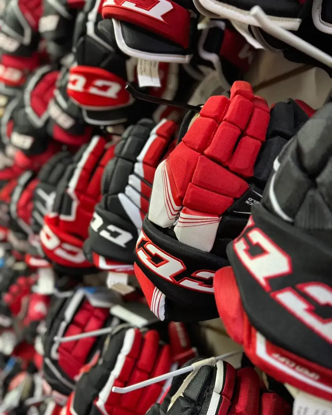 A bunch of hockey gloves are hanging on a wall