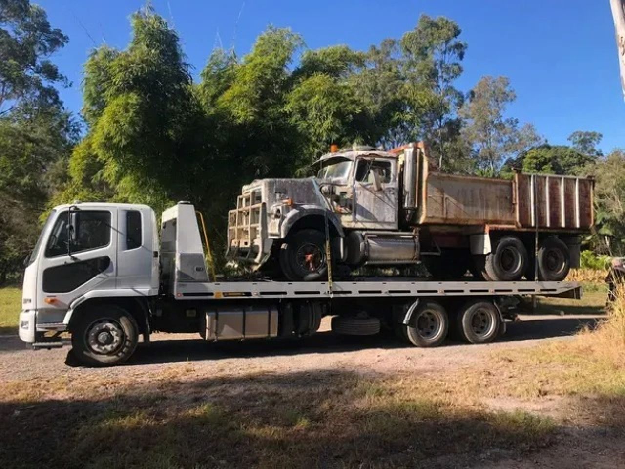 Flatbed Truck Carrying a Grey Dump Truck — ASAP Towing Pty Ltd In Gympie, QLD