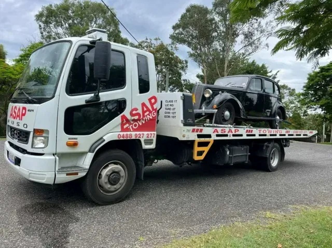 A White Tow Truck Carrying a Black Vintage Car — ASAP Towing Pty Ltd In Gympie, QLD